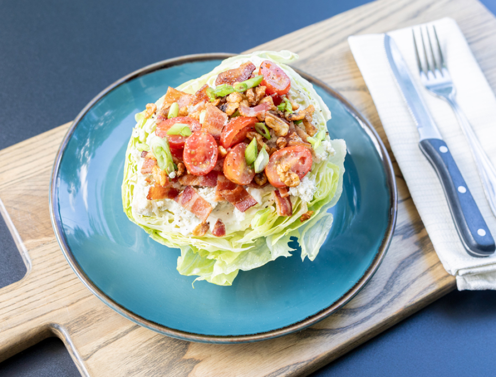 Beat the summer heat with an ice-cold wedge. Candied walnuts play off blue cheese and smoked bacon; alongside cherry tomatoes, scallions, and our famous Black Walnut vinaigrette. Savory meets refreshing in this summer only treat.