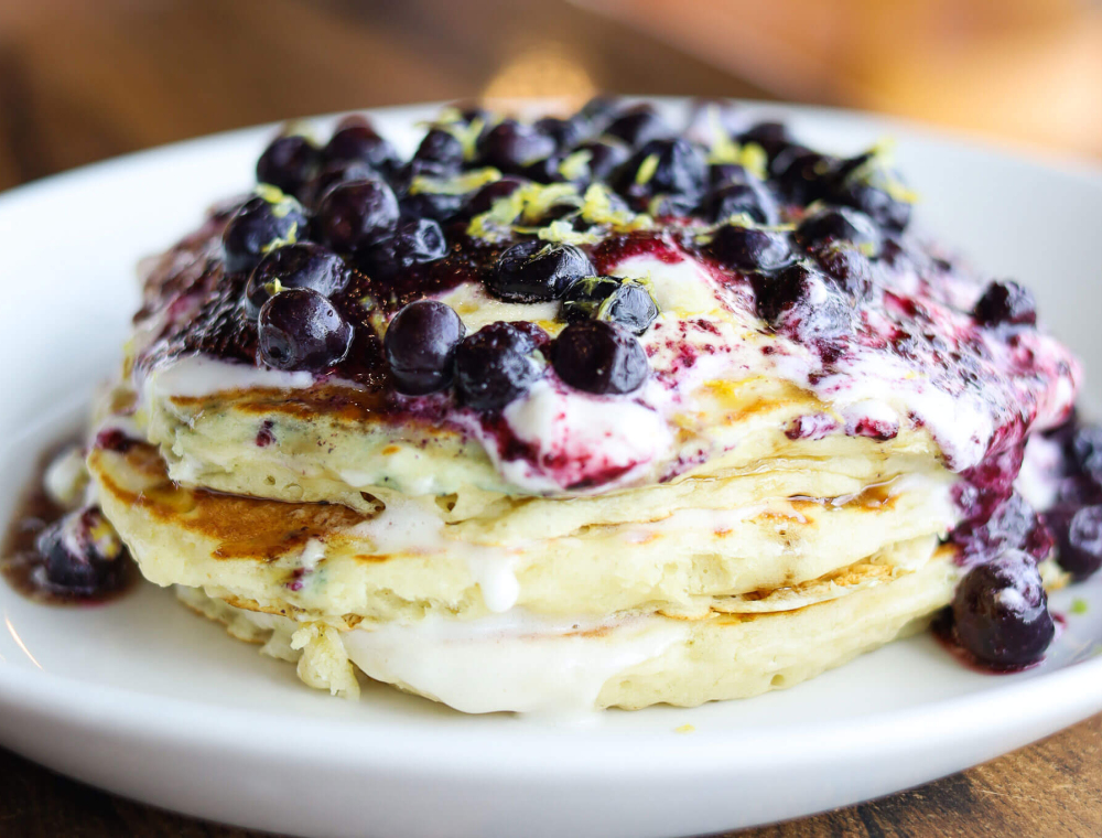 Three house-made buttermilk pancakes, lemon cream cheese icing, blueberry preserves, blueberries, lemon zest, powdered sugar, pure maple syrup