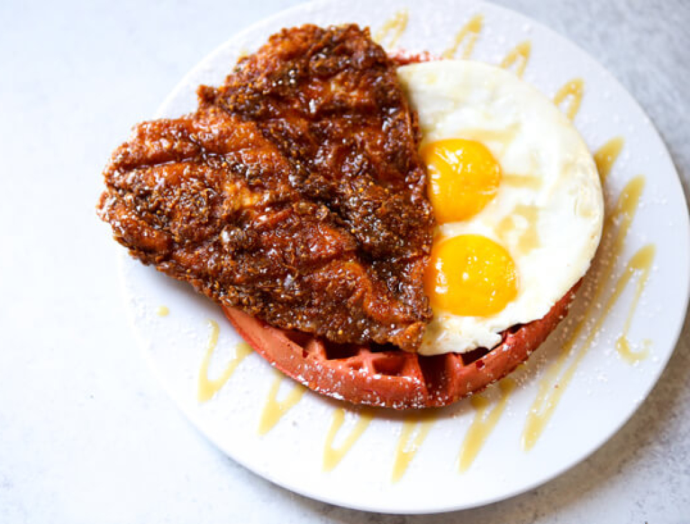 Heat it up with this hot spin on the classic Chicken & Waffles. Served all day (yes, even during dinner!), this dish features crispy hot chicken, two sunny side eggs, red velvet waffle, brown butter honey maple syrup and powdered sugar. Available for dine-in and to-go.