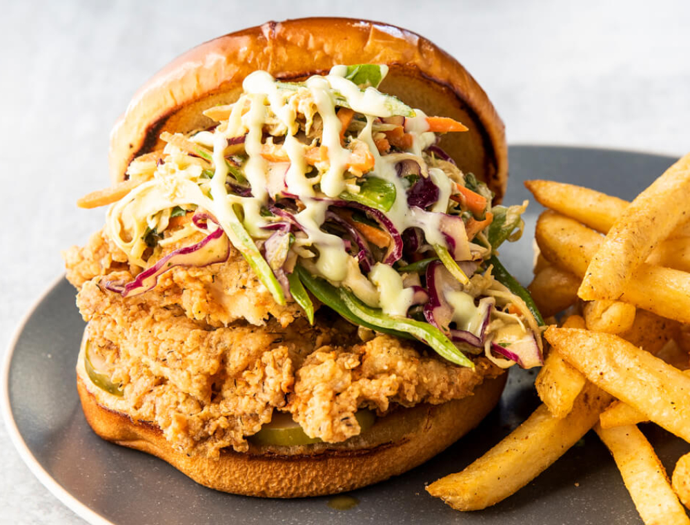 Crispy fried chicken breast; green, red and Napa cabbage; carrots, snow peas, mint, cilantro, house-made pickles, wasabi aioli, honey ginger peanut dressing, brioche bun, choice of house-made potato salad or fries