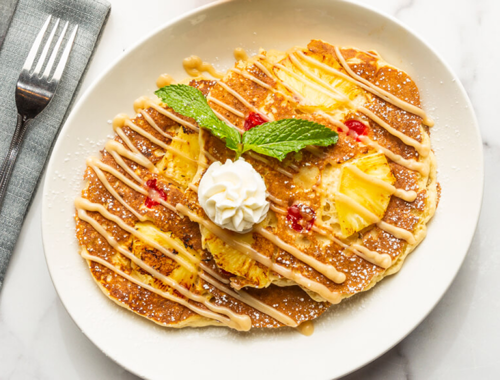 Pineapple, maraschino cherries, rum sauce, powdered sugar, Chantilly whipped cream, mint