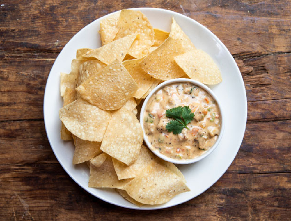 House-made queso, roasted peppers and onions, tomatoes, spicy sausage, cilantro, corn tortilla chips