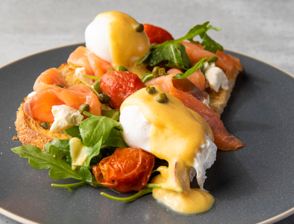 Two extra-large poached eggs, smoked salmon, cream cheese, blistered grape tomatoes, arugula, capers, toasted sourdough, cayenne citrus hollandaise