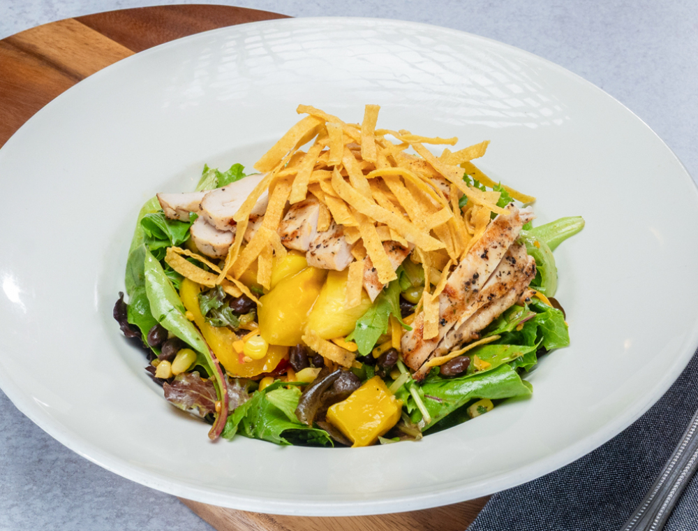 Grilled chicken breast, roasted corn salsa, black beans, mango, cheddar, tortilla strips, sweet bell peppers, mixed greens, spicy mango cilantro dressing
